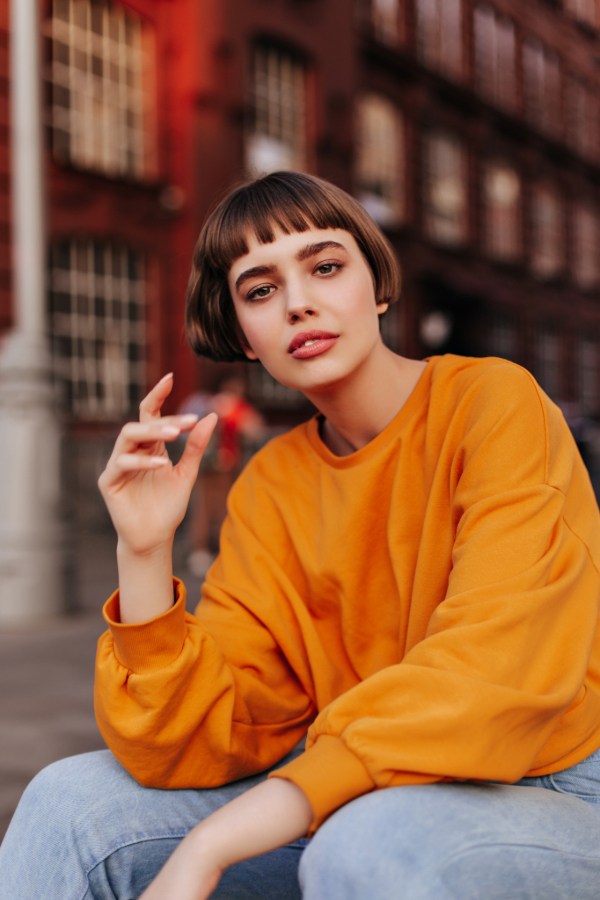 a model in an orange sweater