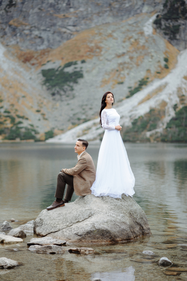 a married couple on a rock in a lake